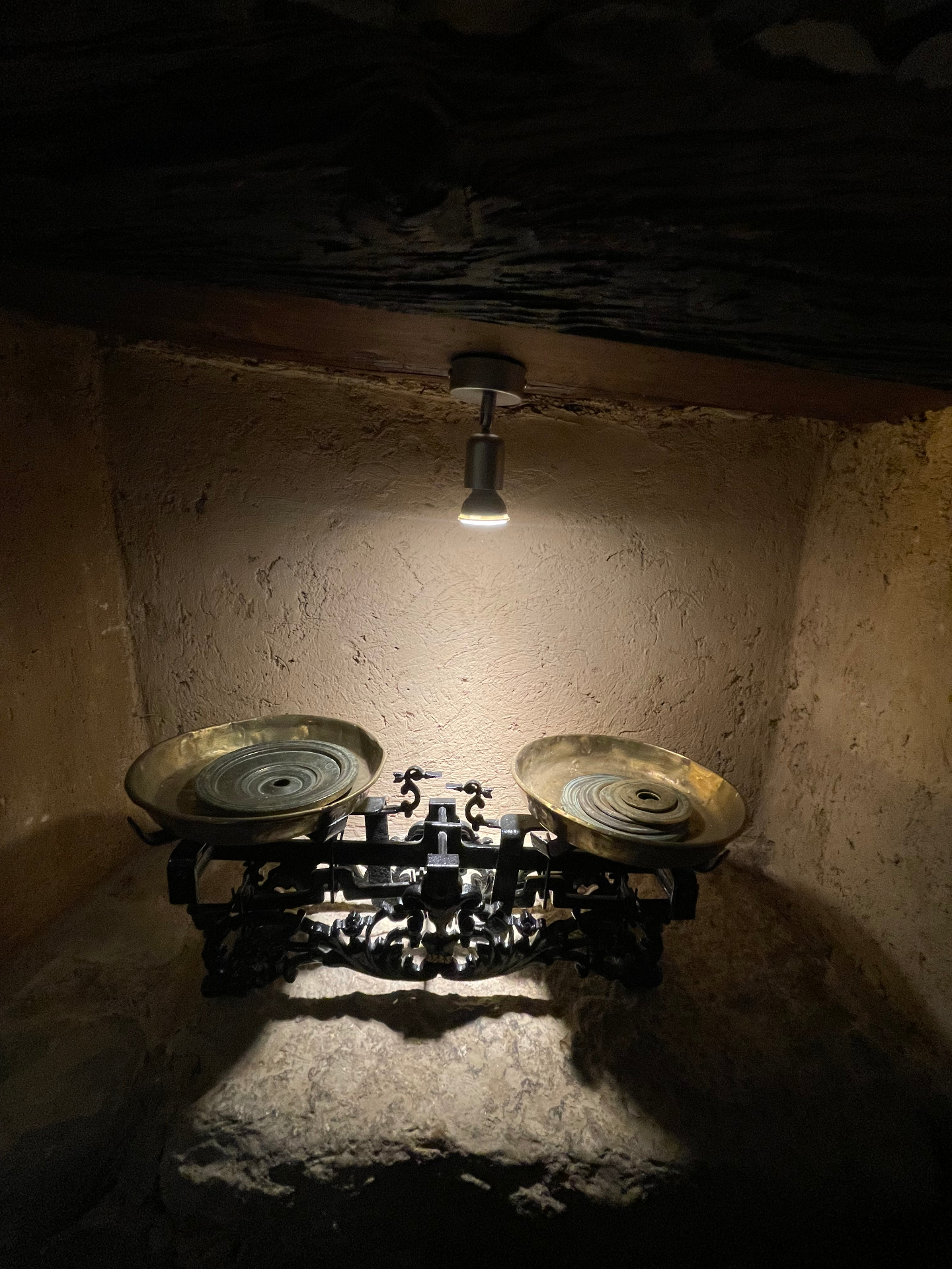 A vintage set of scales lit inside a stone niche