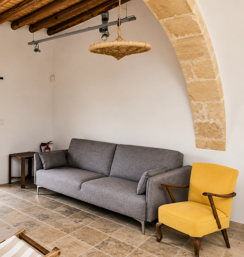The living room with grey sofa and yellow armchair beneath the stone arch